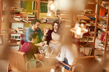 Men and women in conversation in library.