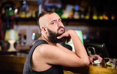 Alcoholism and depression. Alcohol addicted concept. Hipster brutal man drinking alcohol ordering more drinks at bar counter. Guy spend leisure in bar with alcohol. Man drunk sit alone in pub