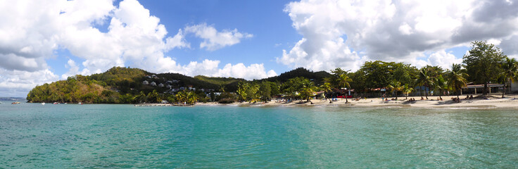 Superb panoramic view from the sea of the beautiful beach of Anse à l'Ane near the village of Trois-Ilets in Martinique facing the city of Fort-de-France