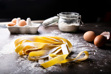 Włoski makaron spaghetti. Domowy makaron na kuchennym blacie. © JacZia