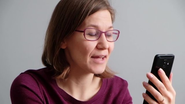 Woman talking with her friend via skype or video call on smartphone