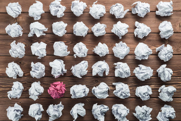 Concept of creativity and inspiration presented by many white paperballs and one color