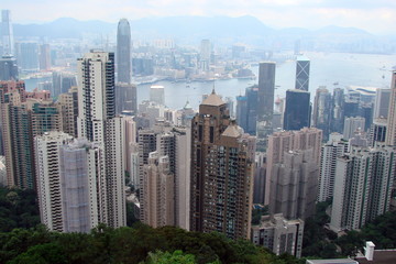 Fototapeta na wymiar A view from above to a variety of skyscrapers of a modern Southern Asian megapolis surrounding the sea bay along its coast.
