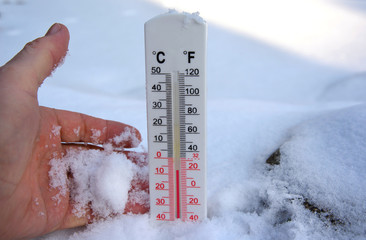 Thermometer on snow shows freezing temperature in celsius or farenheit