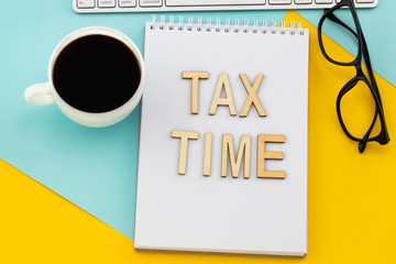 Tax Time - wooden letters with tax form, and cup of coffee