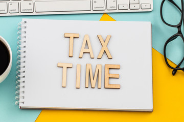 Tax Time - wooden letters with tax form, and cup of coffee