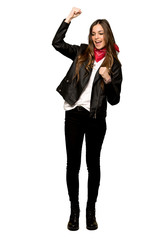 Fototapeta premium Full-length shot of Young woman with leather jacket celebrating a victory on isolated white background