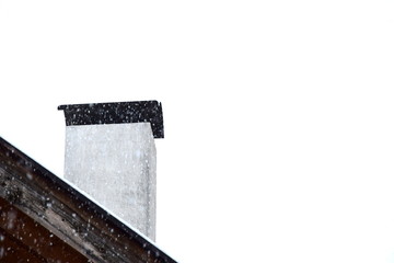 Es schneit - Schneeflocken rieseln auf das Dach und den Kamin