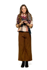 Full-length shot of Young hippie woman sending a message with the mobile on isolated white background