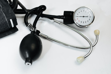 Cardiology. Tonometer and a manometer, stethoscope for diagnosis to measure of blood pressure and pulse, on a white background.
