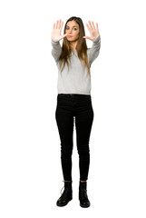 Obraz premium Full-length shot of young girl making stop gesture for disappointed with an opinion on isolated white background