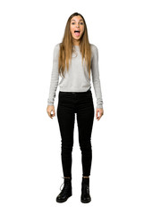 Full-length shot of young girl shouting to the front with mouth wide open on isolated white background