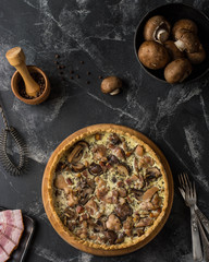 Mushroom Quiche Pie with champignons and cheese on dark background, top view. Savory tart with mushrooms. Galette. Tart with chicken. Chicken pie. Mushroom pie.