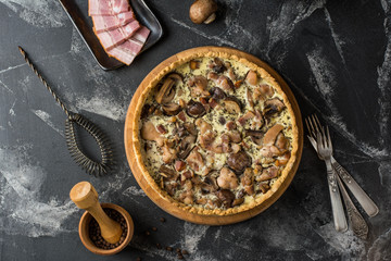 Mushroom Quiche Pie with champignons and cheese on dark background, top view. Savory tart with mushrooms. Galette. Tart with chicken. Chicken pie. Mushroom pie.
