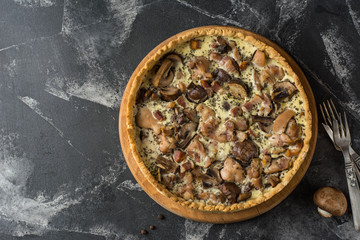 Mushroom Quiche Pie with champignons and cheese on dark background, top view. Savory tart with mushrooms. Galette. Tart with chicken. Chicken pie. Mushroom pie.