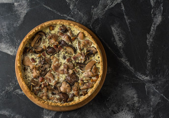 Mushroom Quiche Pie with champignons and cheese on dark background, top view. Savory tart with mushrooms. Galette. Tart with chicken. Chicken pie. Mushroom pie.