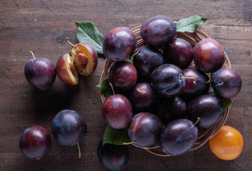 Fototapeta premium Ripe juicy plums on a wooden background.