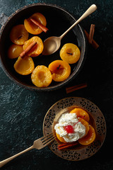 Peach dessert with cinnamon, cream and cherry.