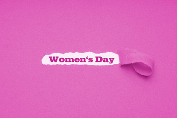 International womens day is celebrated on March 8 - text revealed by hole torn in pink paper...