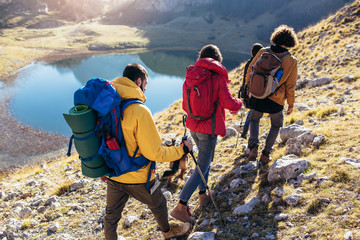 Group of hikers walking on a mountain at autumn day