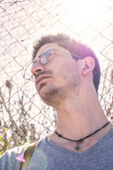 low angle of a caucasian man with the glow of the sun behind him.
