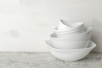 A stack of dishes. tableware on a light concrete background. dishes for serving the table. white bowls in a stack. space for text