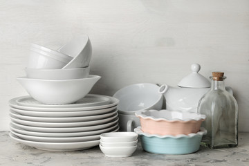 a lot of different dishes. Dinnerware. on a light concrete background. dishes for serving the table. various plates, bowls, and cups.