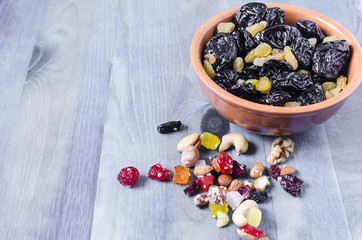 Dried plum and grapes in a Cup on a blue background top view horizontal