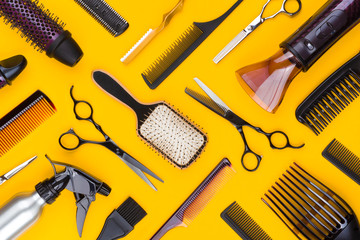 Top view of hairdresser tools and accessories on yellow background