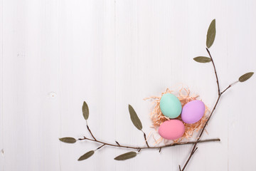 painted Easter eggs lie on a white wooden background, a card for Easter