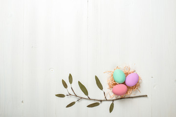 painted Easter eggs lie on a white wooden background, a card for Easter