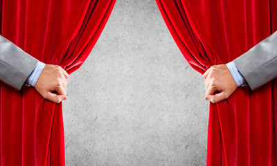 Concrete wall behind drapery curtain and hand opening it