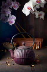 Oriental cast iron tea pot, pistachios, orchid flowers and decorative spices