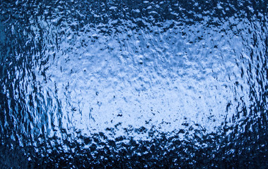 Window covered with ice textured abstract background with a blue hue