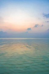 The paradise tropical landscape. Only turquoise clear sea and pink sky. Sunset. Beautiful minimalist background.