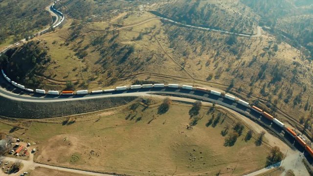 A very long freight train leaving the southern exit of the Tehachapi Railroad Loop. The aerial camera follows the rear end of the several hundred long train.