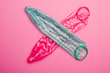 condom cross on pink background