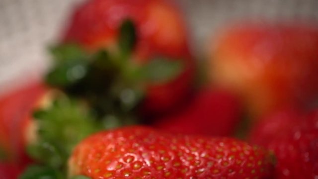 Washing strawberries extreme close up in a strainer. Shot on Batis 25mm on a Sony A7iii.