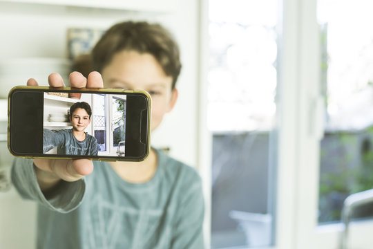 Portrait of a kid making a selfi with the mobile phone. Children with technology