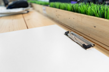 white empty plastic clipboard lay on the wood table.