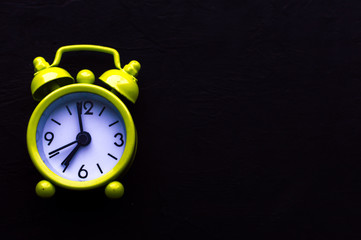 yellow bright alarm clock on black background