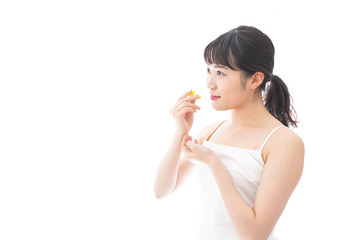 薬・サプリメントを飲む若い女性