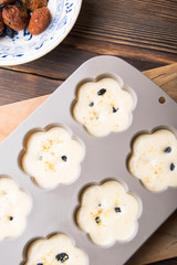 Fototapeta na wymiar dough on muffins in shape on the table