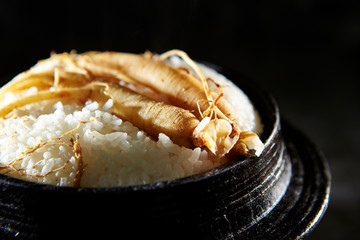 Ginseng root on steamed rice in pot 