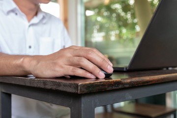 Asian tan skin holding wireless mouse on the vintage wood table