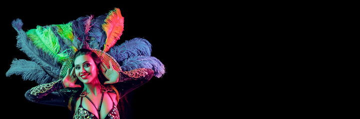 Beautiful young woman in carnival peacock costume. Beauty model woman at party over holiday background with magic glow. Christmas and New Year celebration. Glamour lady with perfect make up and © master1305