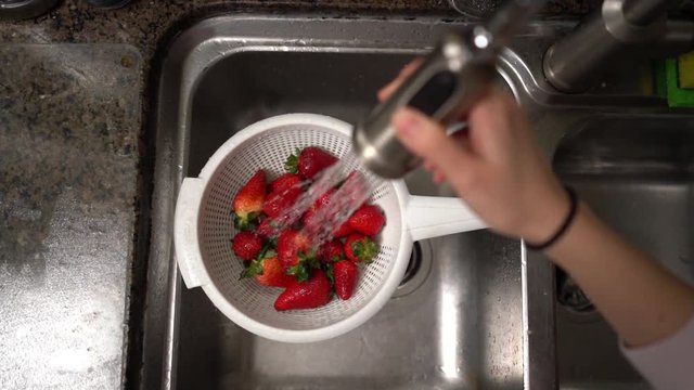 Washing strawberries top down in a strainer. Shot on Batis 25mm on a Sony A7iii and slowed to 25%.