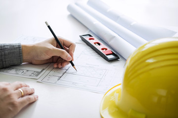 Construction engineering or architect hands working on blueprint inspection in workplace, while checking information drawing and sketching for architecture project working