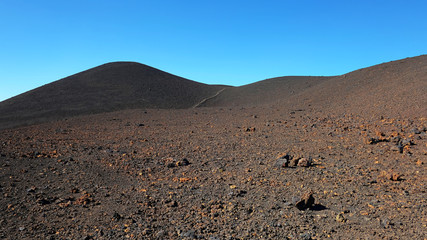 Path through the lunar landscape of Montaña Samara in Teide National Park, one of the most alien-like, volcanic land in Tenerife with views towards Pico del Teide, Pico Viejo, and Las Cuevas Negras