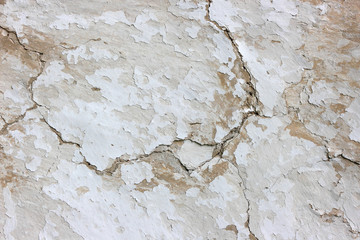 The texture of an aged stucco with cracks.